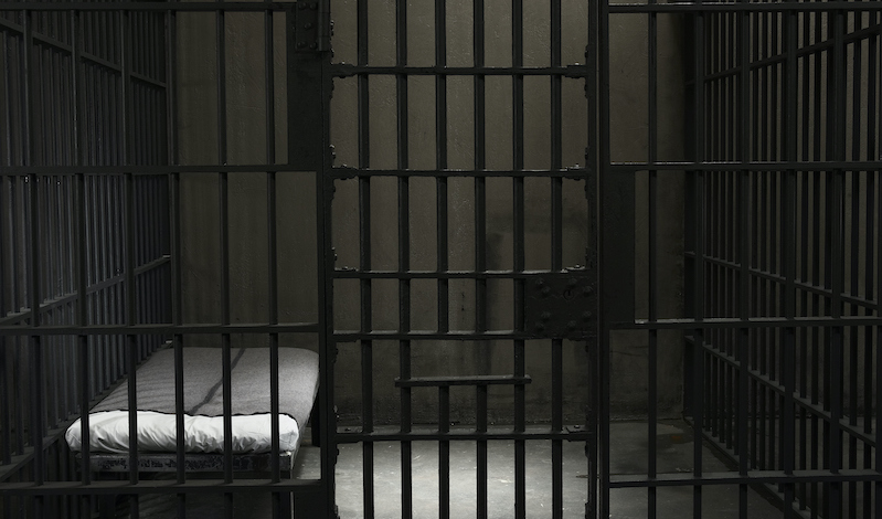 Empty jail cell in the dark.