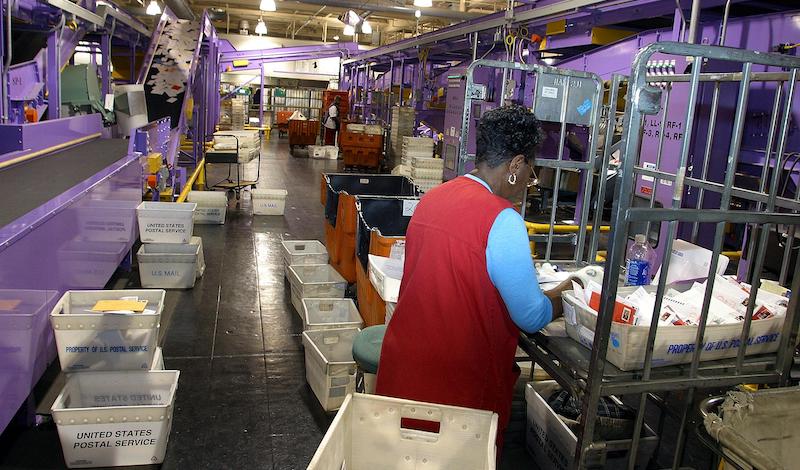 Postal worker sorting mail.